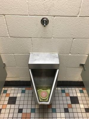 Restroom urinal. Fairly clean for what looks like a public park or detention center restroom