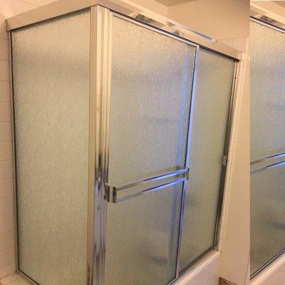 Sliding shower door with all chrome frame and rain style glass installed.