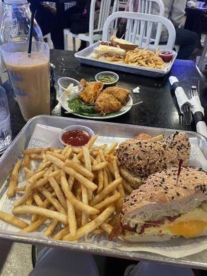 Breakfast bagel with fries, garlic shrimp empanada, short rib empanada, and the "MF" Sando on sourdough