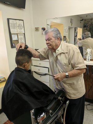 The barber Dion cutting my son's hair.