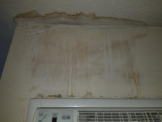 Wall above a/c unit which shows water damage