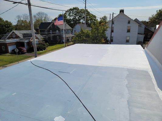 This photo is of a rubber roof restoration.  the blue basecoat has a fabric embedded in it to make this roof rock solid!