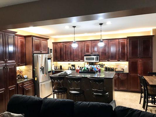 The warm white lighting brightened up this dark cherry kitchen perfectly.