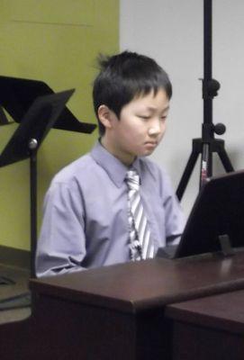 Student playing music on piano