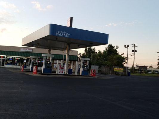 Gas station showing laundry directional sign at right for rear entrance.