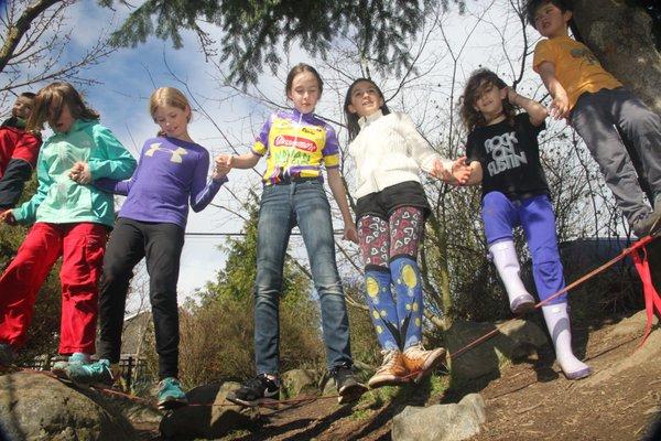 Working together to cross a low rope activity course.