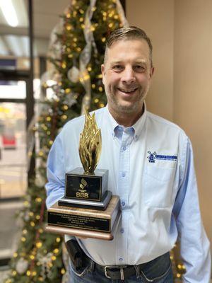 Mike Bakker, owner of Dutchman Heating and Cooling, and the Better Business Bureau Torch Award won by Dutchman.