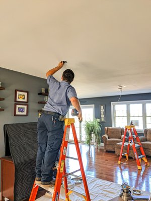 In the process of installing a ceiling fan.