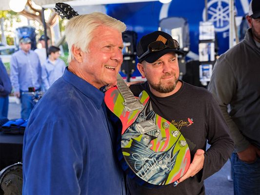 Dennis Friel hand paints a guitar for charity in Jimmy Johnson's tournament every year.