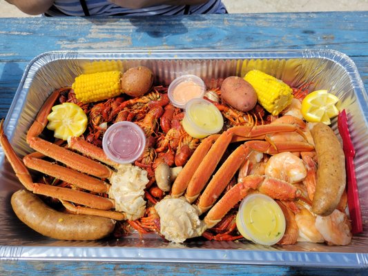 Cajun Feast- 3 lbs crawfish, 1 lbs huge shrimp, 2 crab clusters, 2 potatoes, 2 corn, 2 sausages, pluse butter and remoulade sauce.