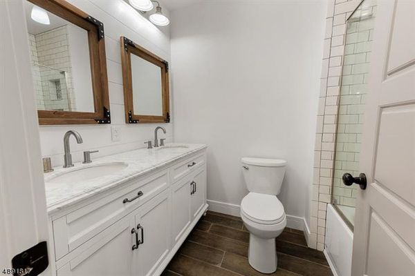 All white bathroom with subway tile, custom mirrors, and PVC ship lap back splash