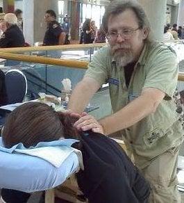 Ray doing chair massage at an event at the San Jose Convention Center