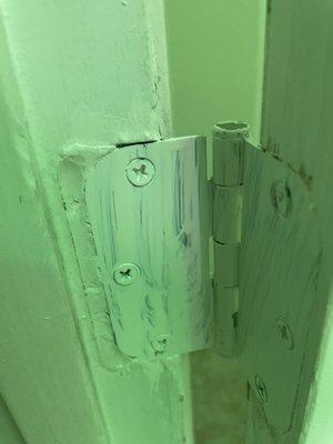 Extended door hinge from wooden door frame. Poor quality work from installer trying to make an improper door he cut incorrectly fit.