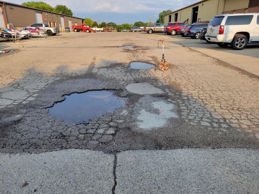 this is a before picture of a commercial parking lot that had patching, sealcoating and Striping done