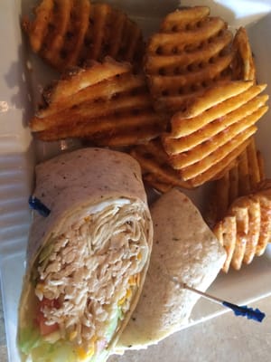 Grilled chicken wrap with waffle fries.