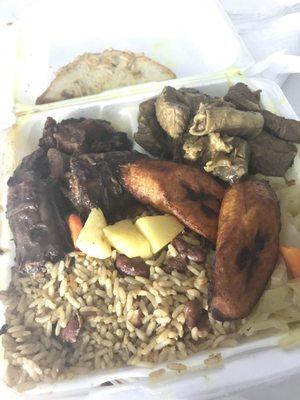 Oxtails and curry goat with rice and beans, cabbage, plantains, and bread.