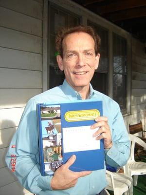 The inspector on the front porch of his 1925 home presenting the Homebook report binder.