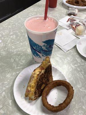 Pimento cheese grilled sandwich with crispy onion rings and strawberry milkshake. Must try items.