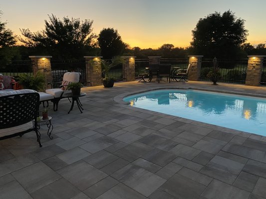 Pavers and lights around a pool can make your backyard a oasis!