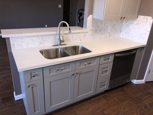 Grey Shaker Cabinets, quartz countertops and new tile backsplash with a stainless under mount sink in Dickinson