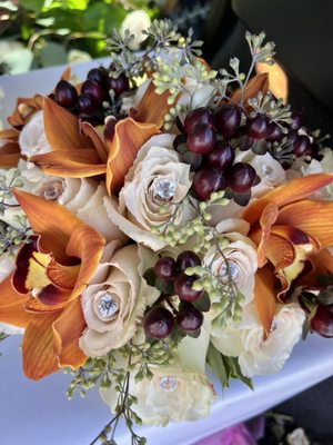 Cymbidium orchids with roses, brown hypericum berries and seeded eucalyptus.