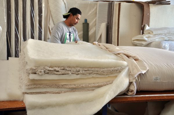 Miguel showing off the inside of a raw organic mattress prior to being upholstered.