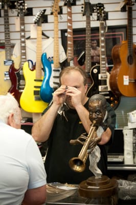 Tom the manager looking at gold jewelry they are buying for cash