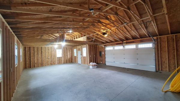 Vaulted ceiling over vehicle area for lift and storage area over room.