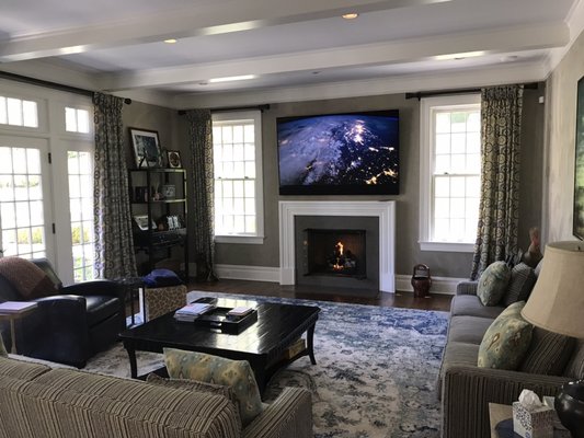 82" 8k tv installed above a fireplace