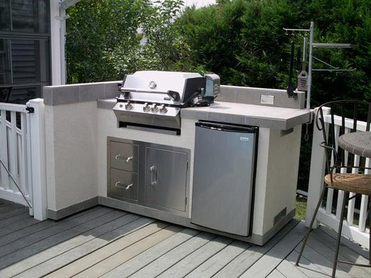 5' wide Outdoor kitchen. Base island measure 66" and includes stainless steel door, drawers, fridge, and 3 burner grill.