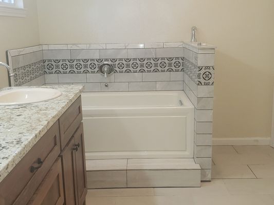 Jacuzzi tub with tile & step.