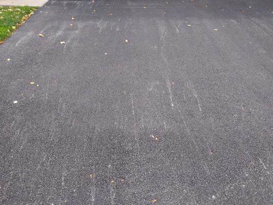 Long view of streaky asphalt driveway.