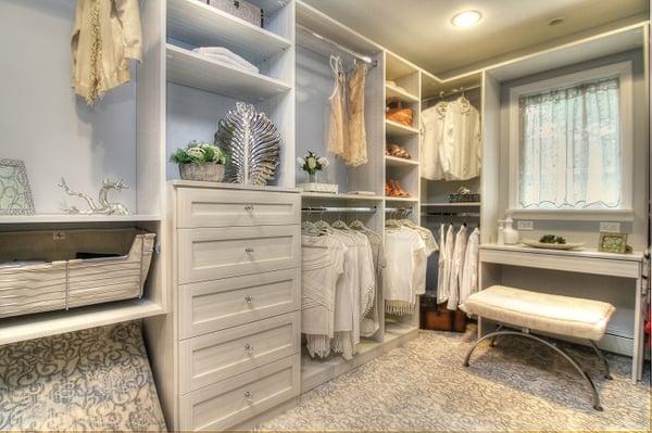 Custom closet design by Symmetry Closets. A beautiful walk-in closet with shaker drawers and slide-out basket storage.