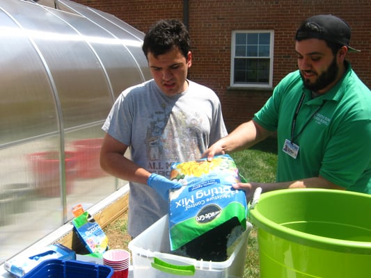 Student and staff working in the garden.