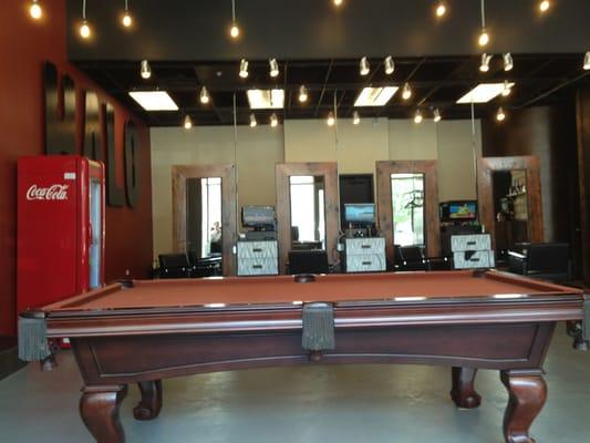 A lounge area with pool table for use before or after your cut.