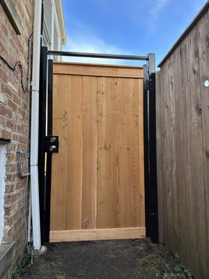 6' high cedar traditional metal frame gate with metal posts.