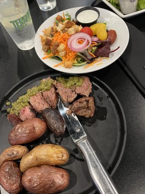 Flank steak with potatoes (they forgot to season them!) and side salad