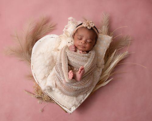 newborn girl in heart prop