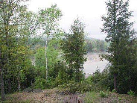 You cant beat this view from this riverfront 5 bedroom 3 bath log with 2 kitchens and 2+ acres on Pemi River only 349,900