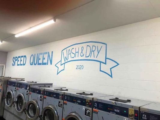 Wall of laundromat with laundromat logo.