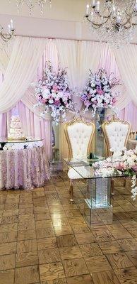 Indoor bride and groom's table with cake in the background